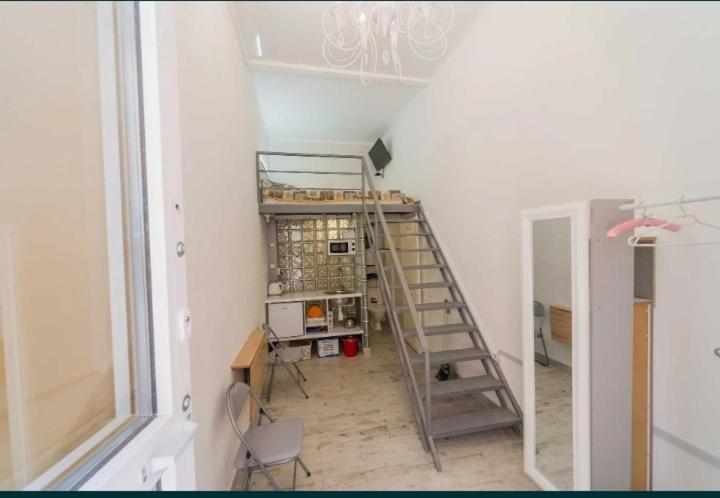 um quarto com uma escada e uma secretária num quarto em Смарт квартира в центре Одессы em Odessa