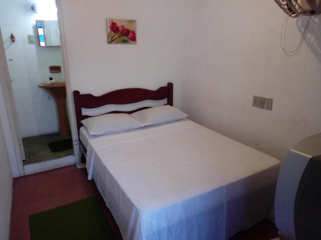 a small bedroom with a white bed in a room at Hotel Hangar in Bagé