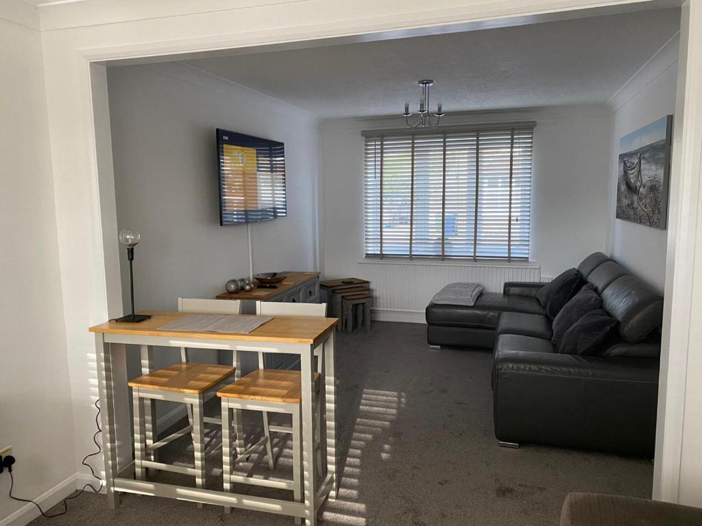 a living room with a couch and a table at Riverside Park Ground Floor Apartment - St Neots in Saint Neots