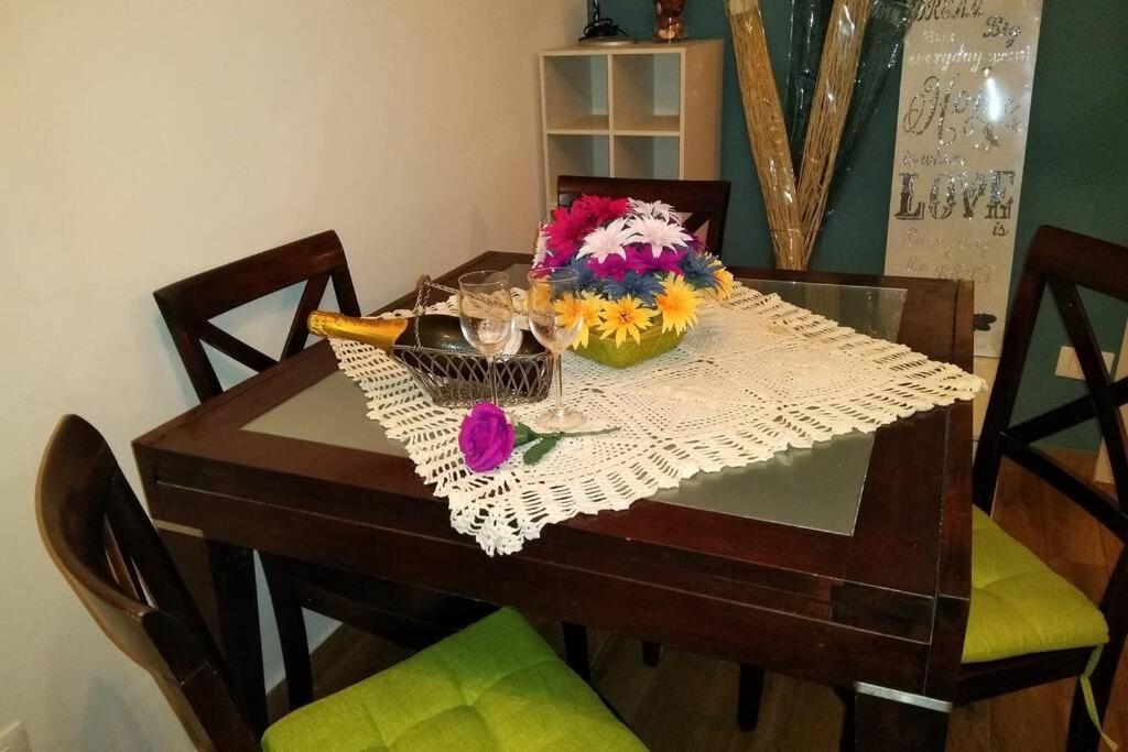 einen Holztisch mit Blumen und Gläsern darauf in der Unterkunft Casa Sgurghy in Sgurgola