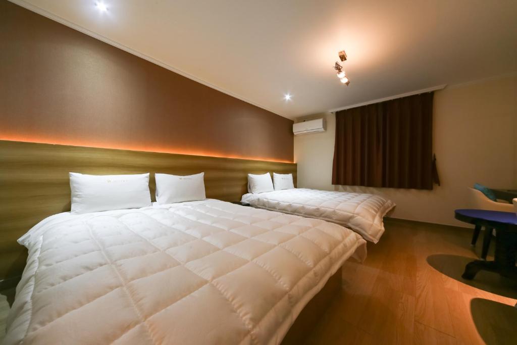 Postel nebo postele na pokoji v ubytování Gyeongju bulgooksa W Drive-in Motel