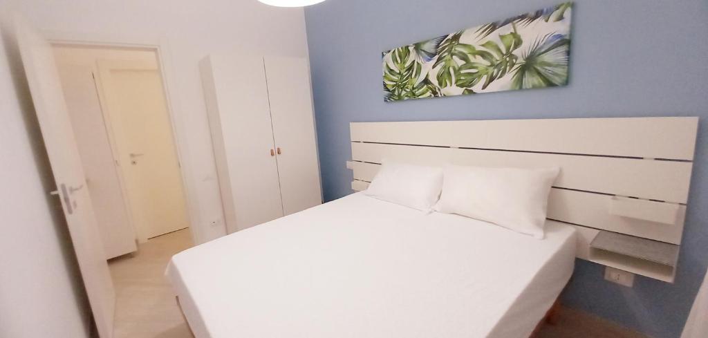niewielka sypialnia z białym łóżkiem i niebieską ścianą w obiekcie 11 at beach w mieście San Salvo