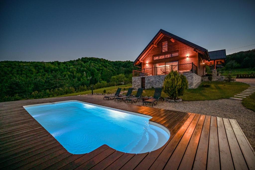 einen Pool auf einer Terrasse neben einem Haus in der Unterkunft kuća za odmor Casa Kapusta in Ogulin