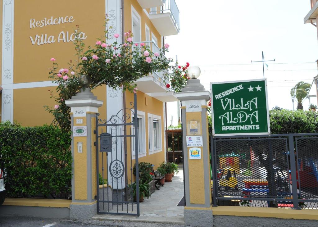 budynek z bramą z kwiatami w obiekcie Residence Villa Alda w mieście Pietra Ligure
