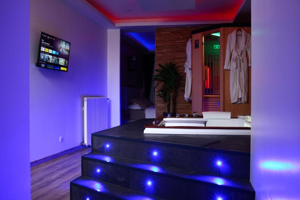 Spa privatif by XELA في أوكسير: غرفة سبا مع حوض استحمام مع أضواء أرجوانية