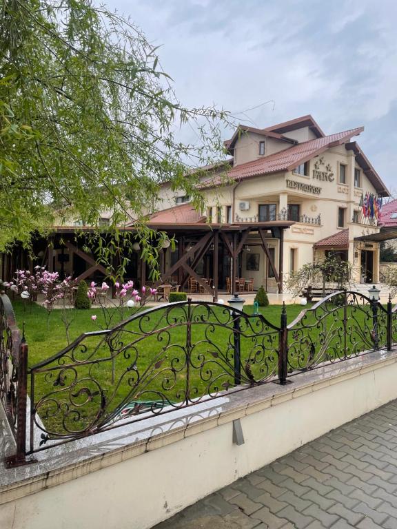 a fence in front of a house with a yard at Hotel Parc Tecuci in Tecuci