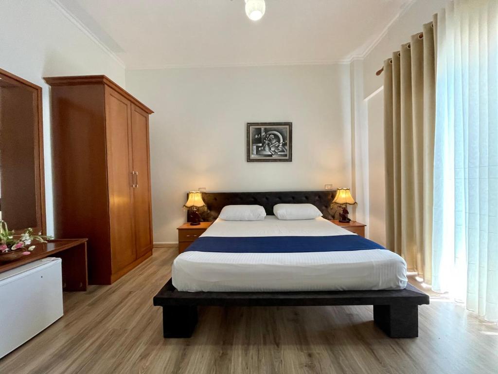 1 dormitorio con 1 cama grande y 2 almohadas en Hotel Benilva, en Durrës
