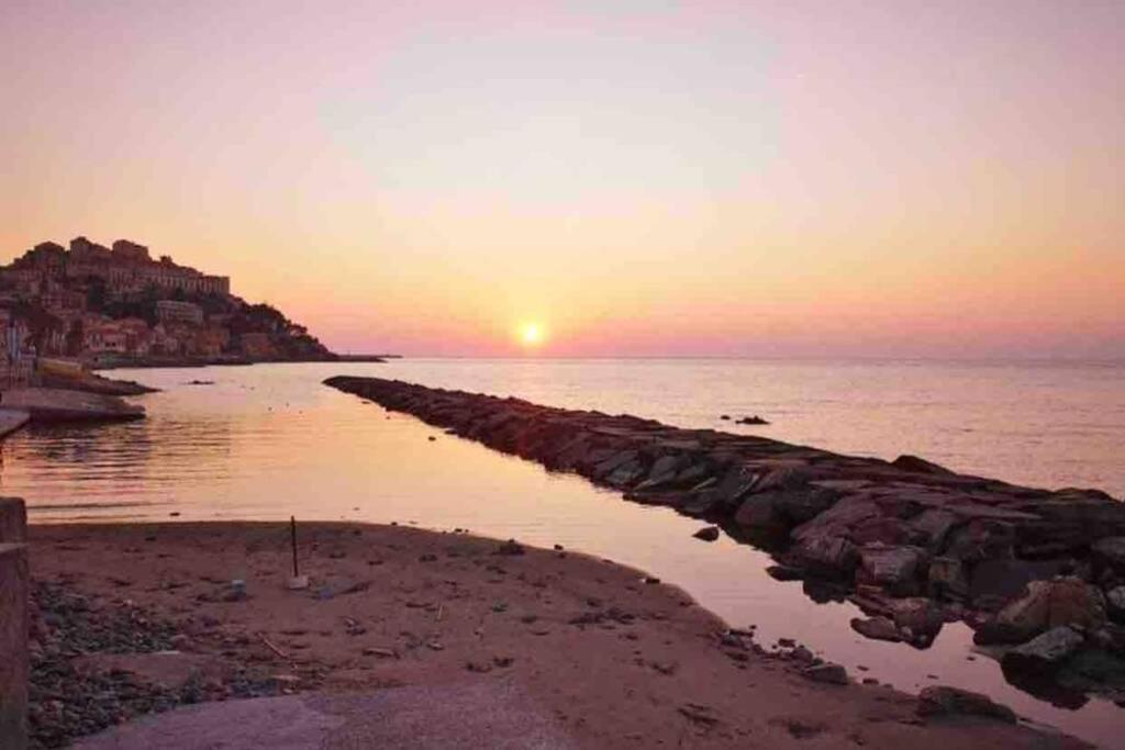 a sunset over a body of water with a pier at Appartamento sul mare alla Foce in Imperia