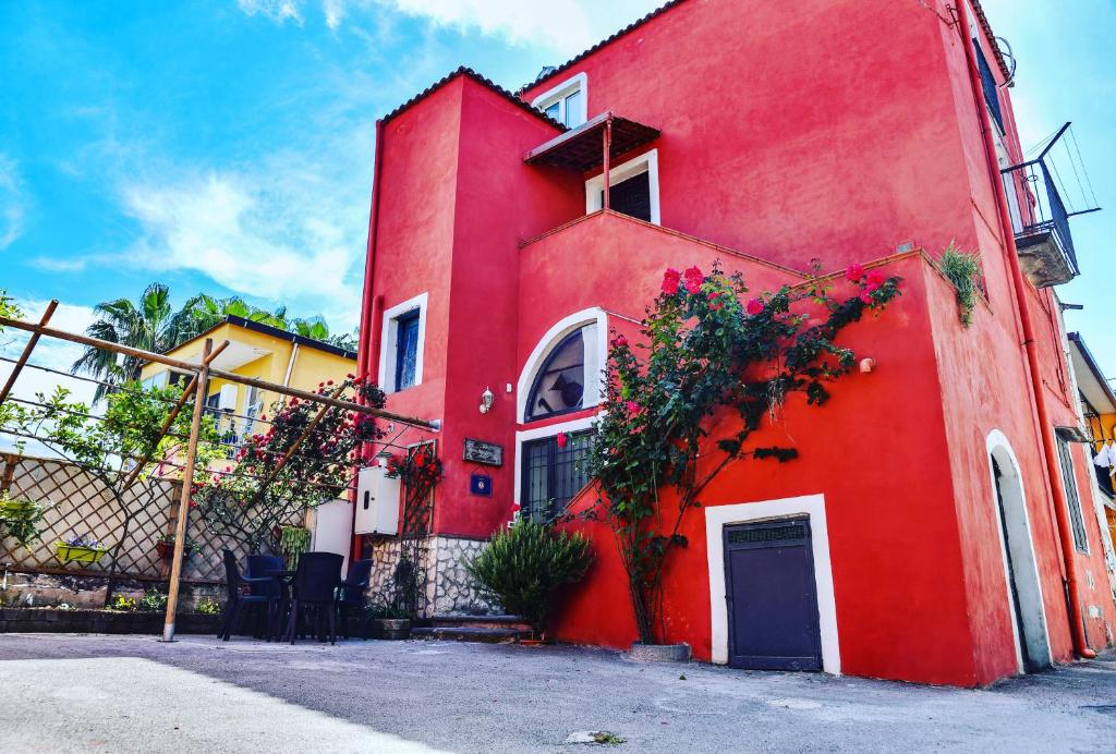 un bâtiment rouge avec une porte bleue dans une rue dans l'établissement Domus Carolina, à Pompéi