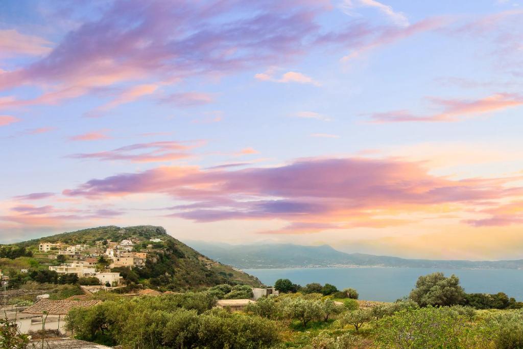 a view of a town on a hill with a cloudy sky at Poseidon Apartments in Kissamos