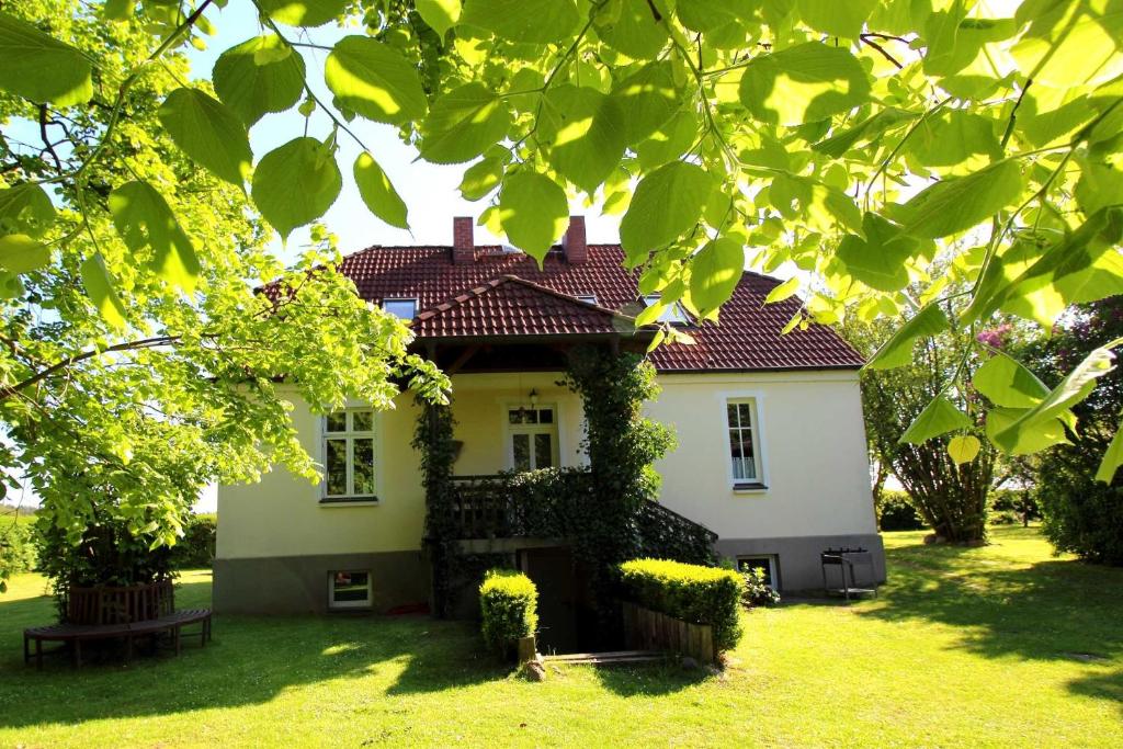 ein weißes Haus mit rotem Dach im Hof in der Unterkunft Ferienhaus Ratteyer Idyll in Schönbeck