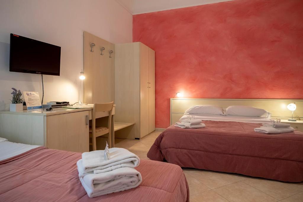 トラーパニにあるSoleTerraLunaのベッド2台とデスクが備わるホテルルームです。