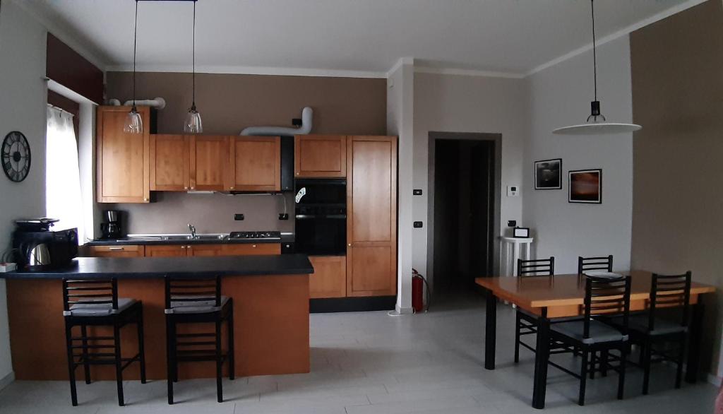 una cocina con armarios de madera, mesa y sillas en Casa Silvia, en Padenghe sul Garda