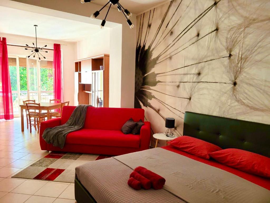 sypialnia z czerwonym łóżkiem i czerwoną kanapą w obiekcie Viale Umberto I Apartments w mieście Sassari