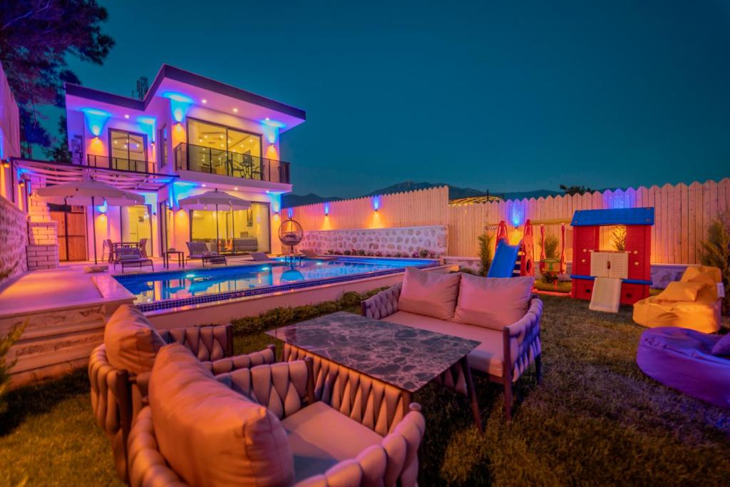 uma casa com uma piscina com sofás e uma mesa em Emirbey - 2 Bedroom Holiday Villa with jacuzzi in Kalkan em Kas