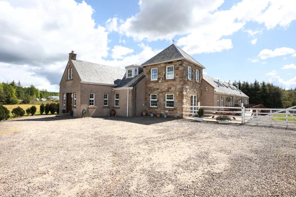 a large brick house on a gravel driveway at ALTIDO Greenknowes Estate - Retreat With Garden, Parking and Hot Tub in Kelty