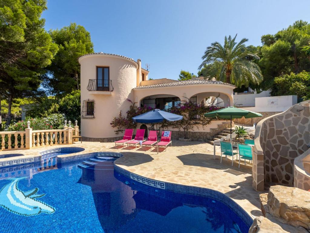 Villa con piscina con sillas y sombrillas. en Holiday Home Toscamolino by Interhome en Balcón del Mar