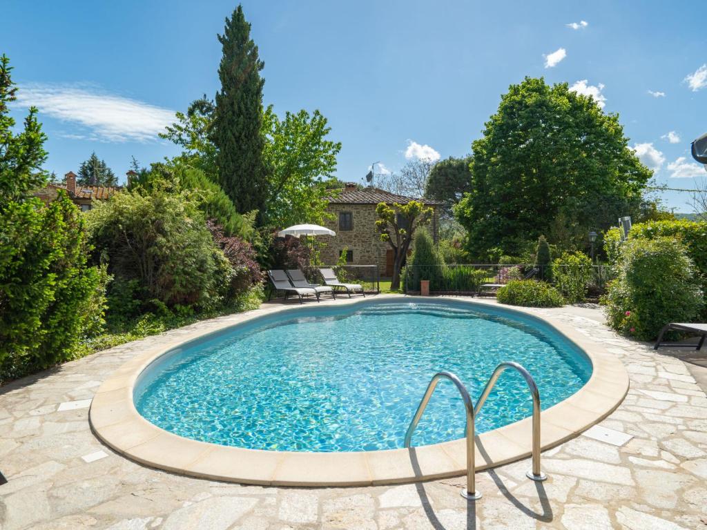 a pool in a yard with a patio and trees at Holiday Home Casale il Giglio-1 by Interhome in Ciggiano