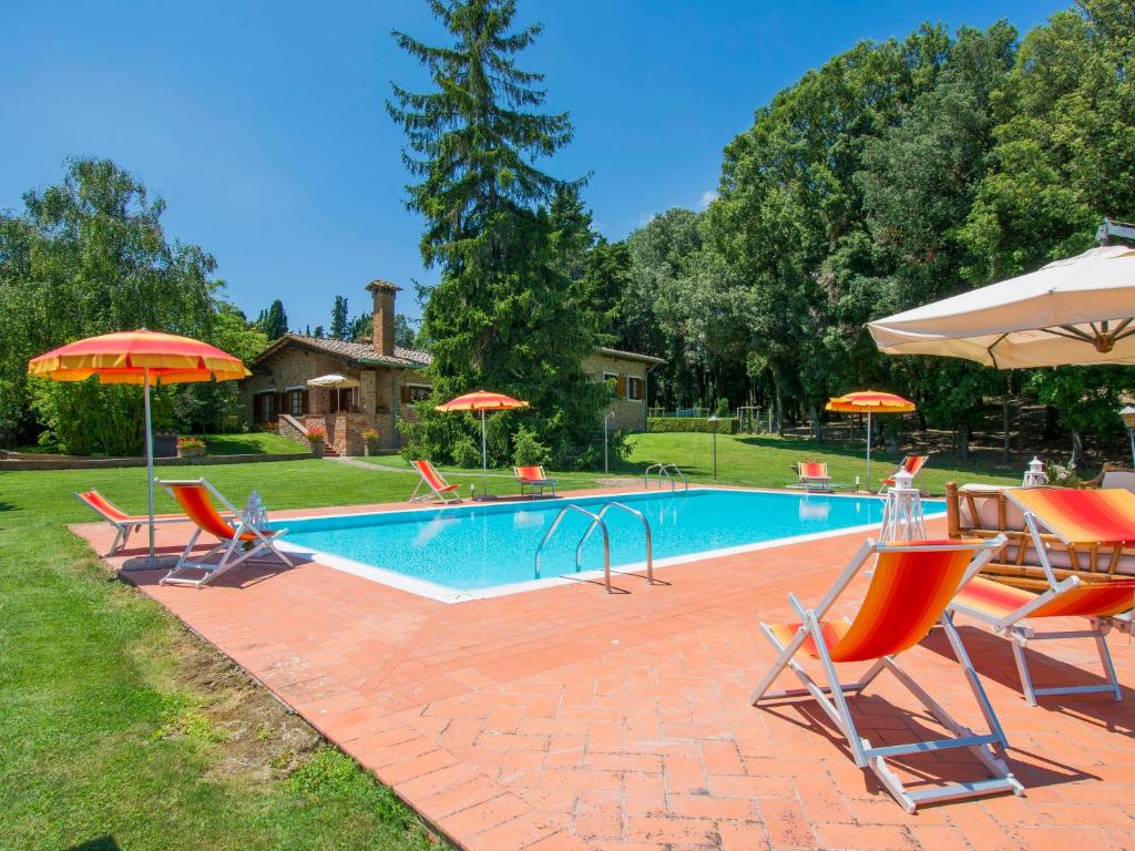 a swimming pool with chairs and umbrellas at Villa Camporbiano by Interhome in Camporbiano