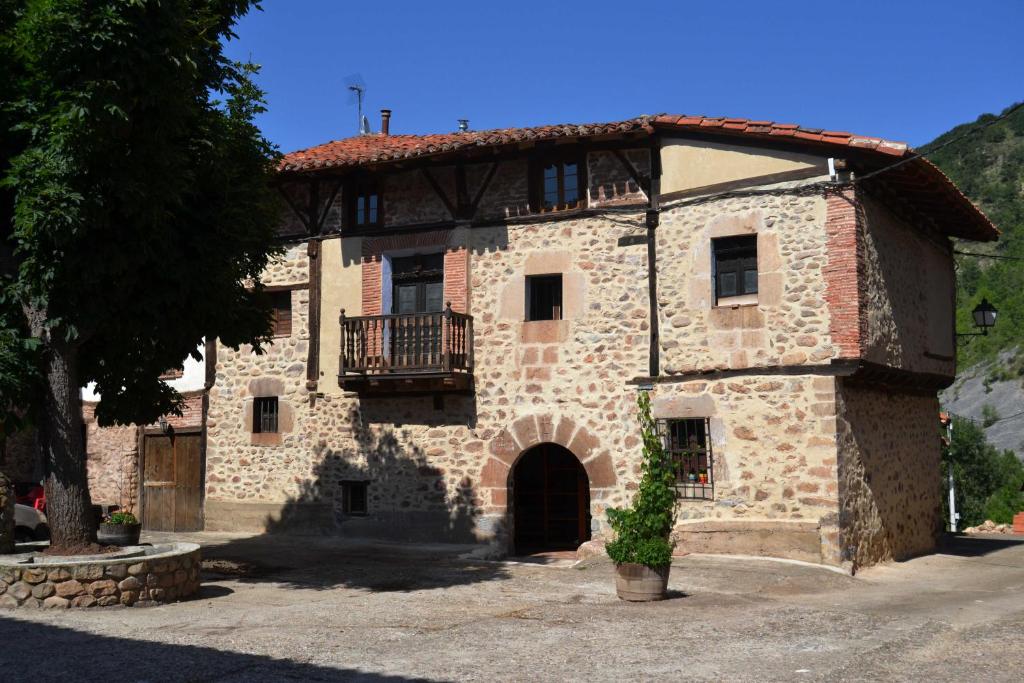 un gran edificio de piedra con balcón en la parte superior en SOLAR de 1709, en Pradillo