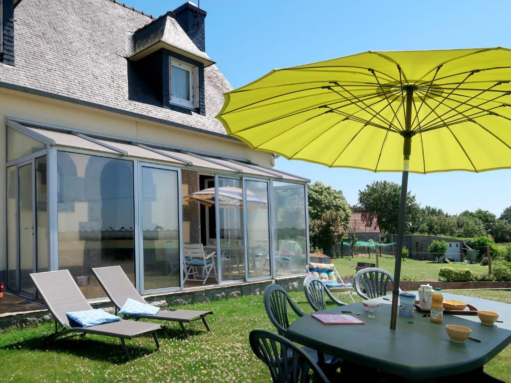 a table with a yellow umbrella on a patio at Holiday Home Les Hortensias - KSD101 by Interhome in Kermaria-Sulard