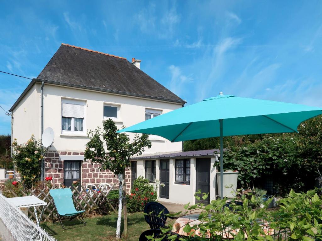 a blue umbrella and chairs in front of a house at Holiday Home La Corvette by Interhome in Pléneuf-Val-André