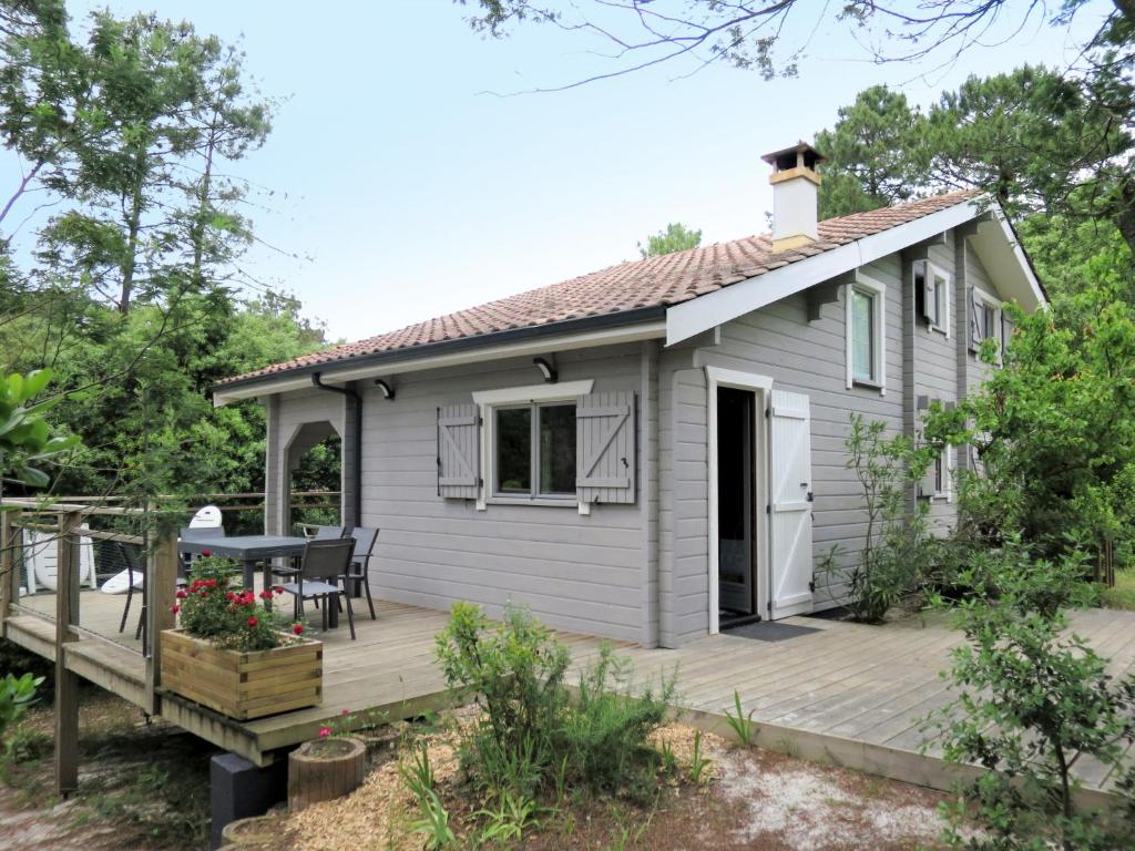 a tiny house with a deck and a table at Holiday Home L'Escouarte - MAU170 by Interhome in Maubuisson