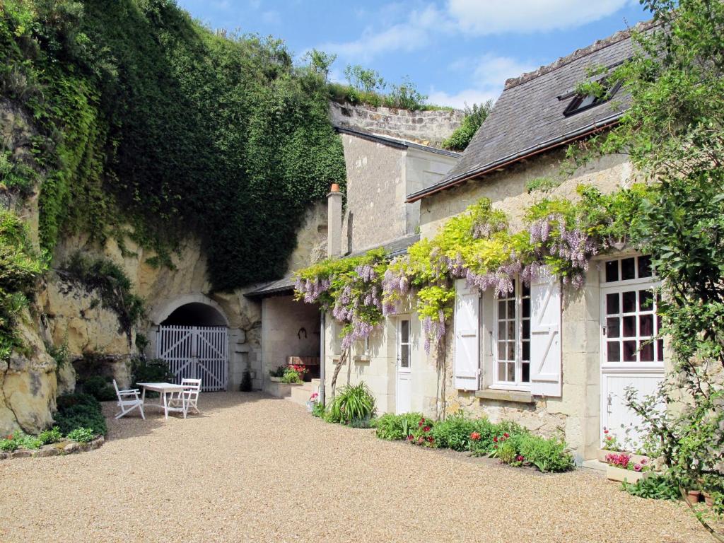 Une vieille maison avec une table et des fleurs devant elle dans l'établissement Holiday Home Le Coteau Fleury - LYE100 by Interhome, à Luynes