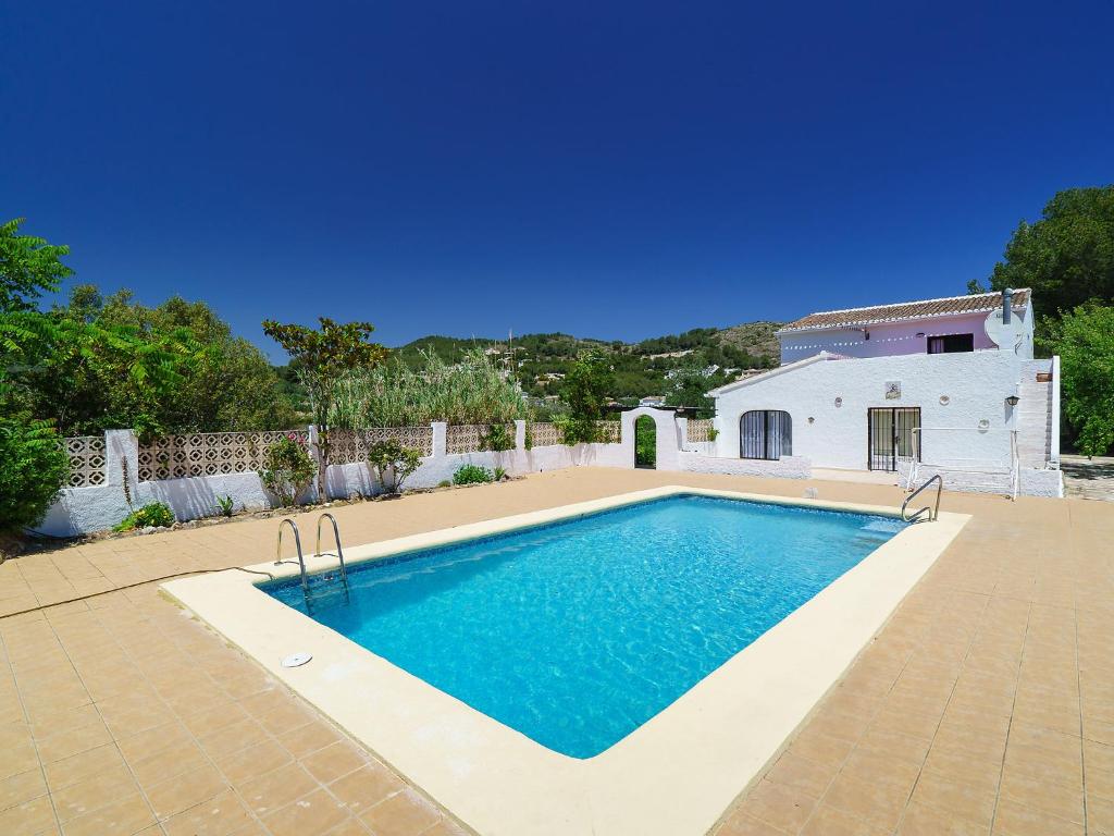 a swimming pool in front of a white house at Holiday Home Forest by Interhome in Benitachell