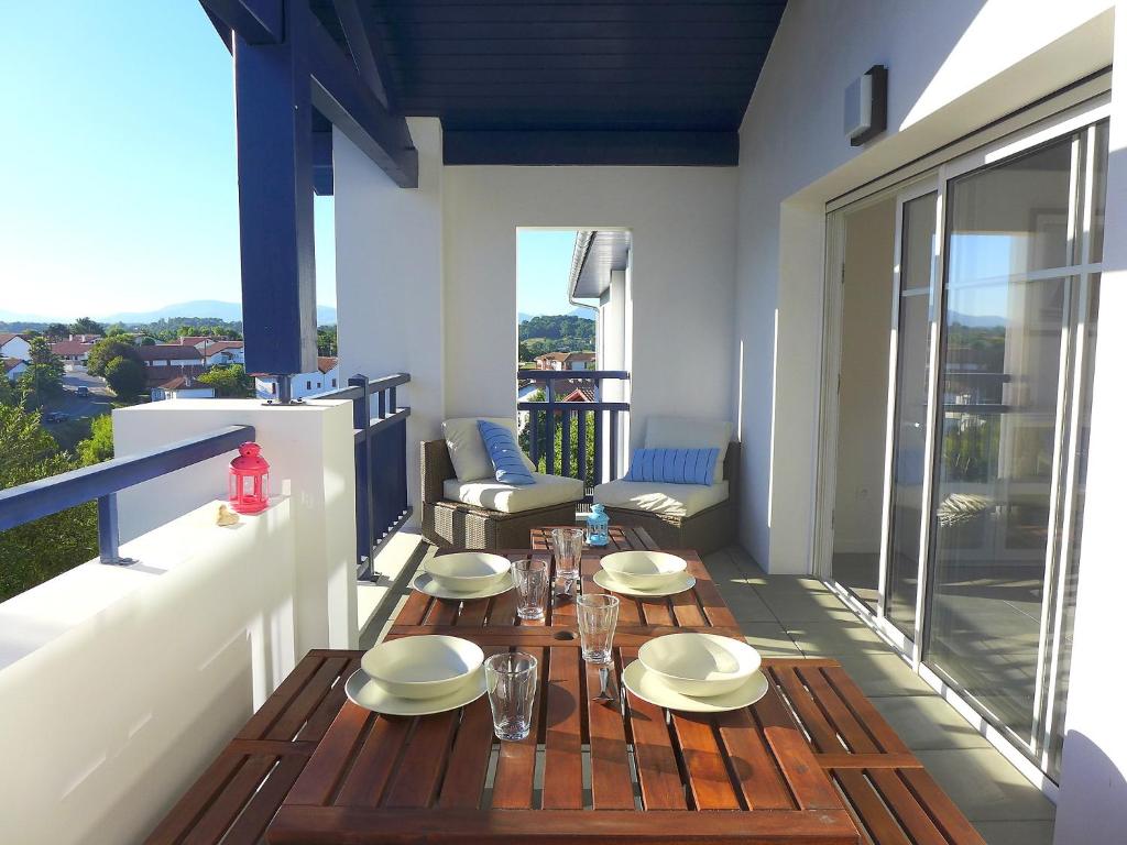 a balcony with a table with plates and glasses on it at Apartment Xabadenia-1 by Interhome in Bidart