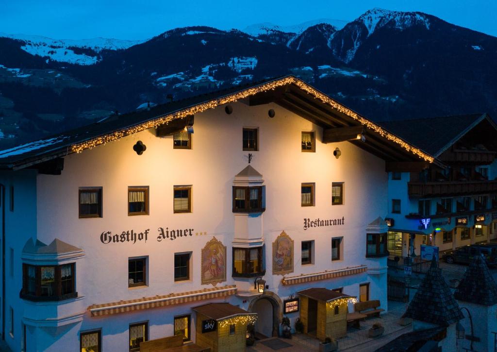 a large white building with mountains in the background at Gasthof Aigner *** in Fügen