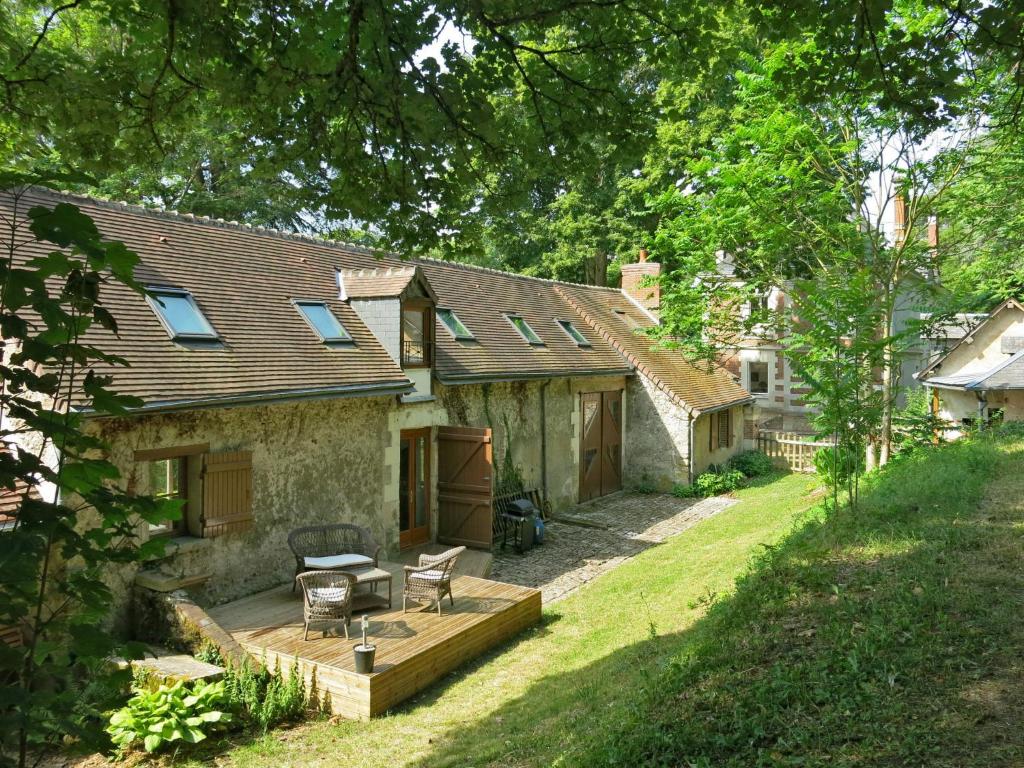 a stone house with a wooden deck in the yard at Holiday Home Marray-Baccus - OZN200 by Interhome in Onzain