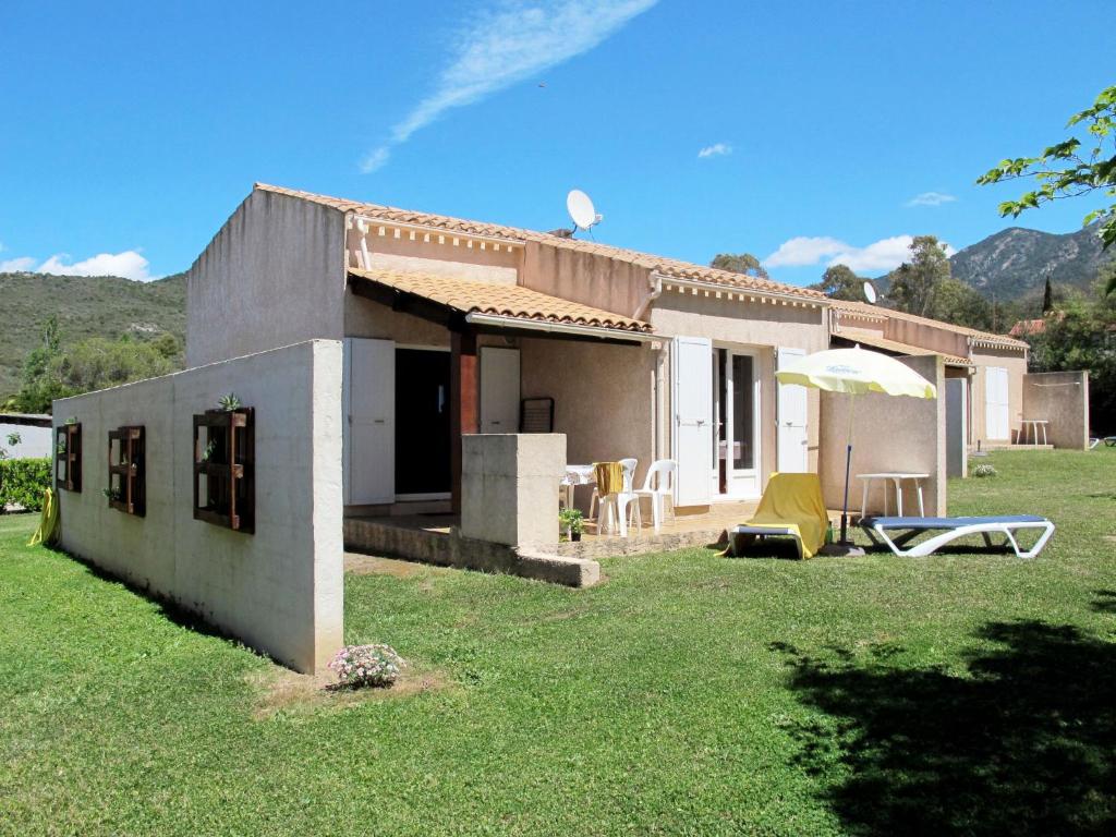 ein kleines Haus auf einem Feld mit einem Rasenplatz in der Unterkunft Holiday Home La Pinede - SAG171 by Interhome in Sagone