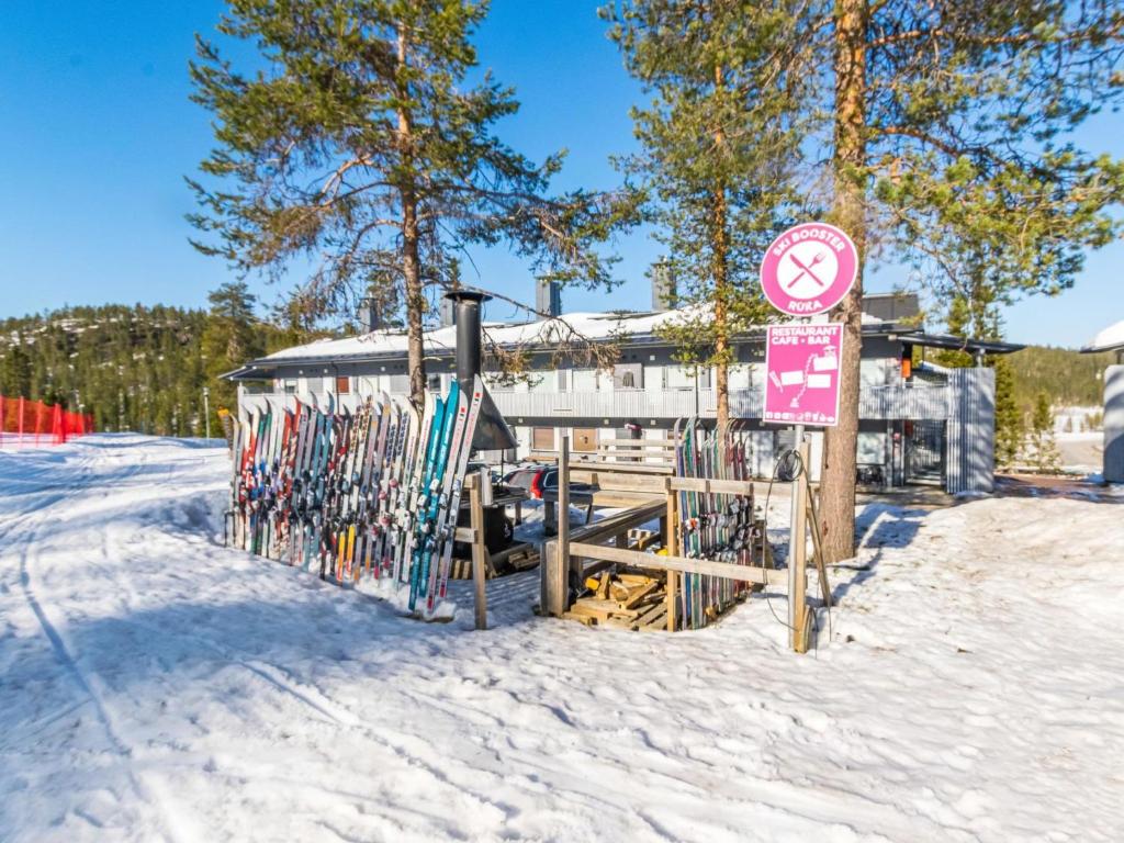 ein Schild auf einem Zaun im Schnee neben einem Gebäude in der Unterkunft Holiday Home Vuosselinhelmi c6 by Interhome in Ruka