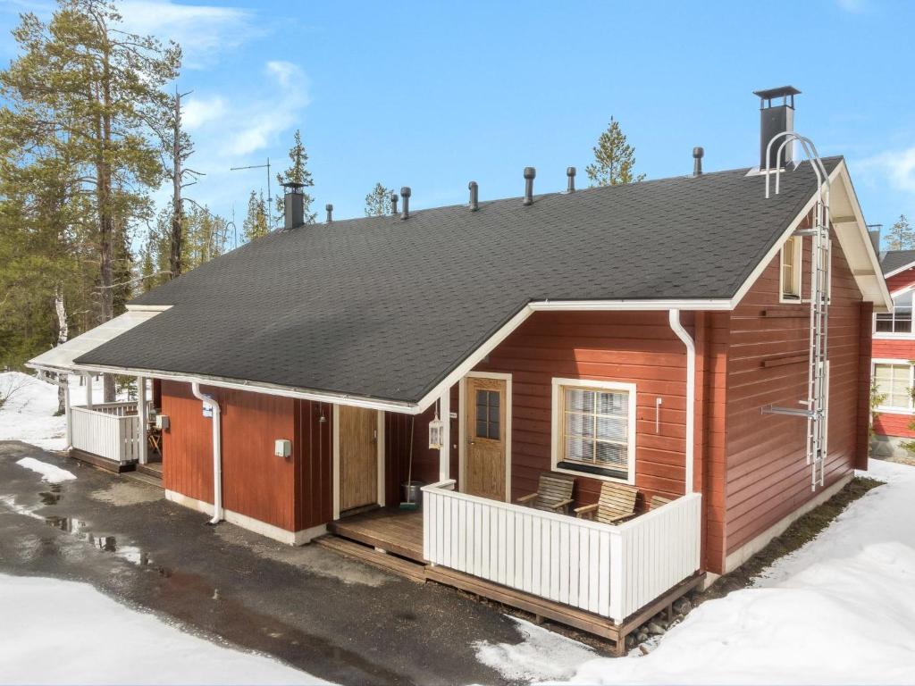 レヴィにあるHoliday Home Nuottiukko by Interhomeの雪の中にポーチのある木造家屋