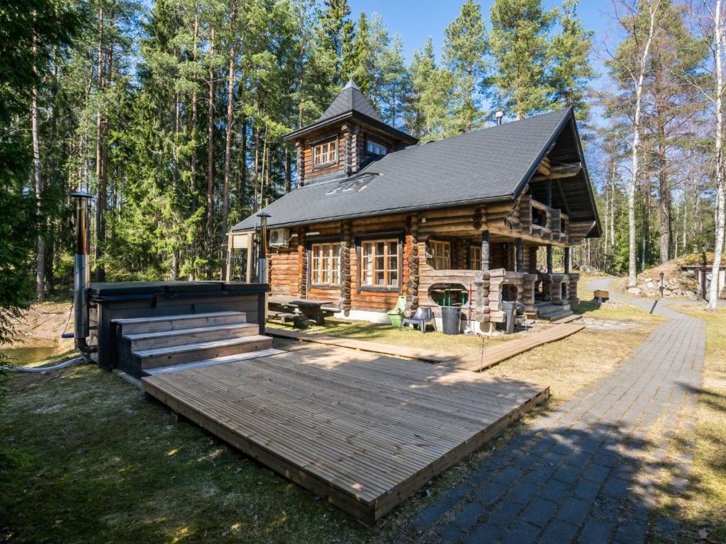 eine Blockhütte im Wald mit einer Holzterrasse in der Unterkunft Holiday Home Villa irene by Interhome in Parikka