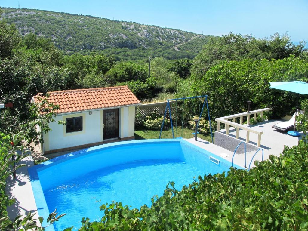 a villa with a swimming pool and a house at Apartment Stella by Interhome in Bribir