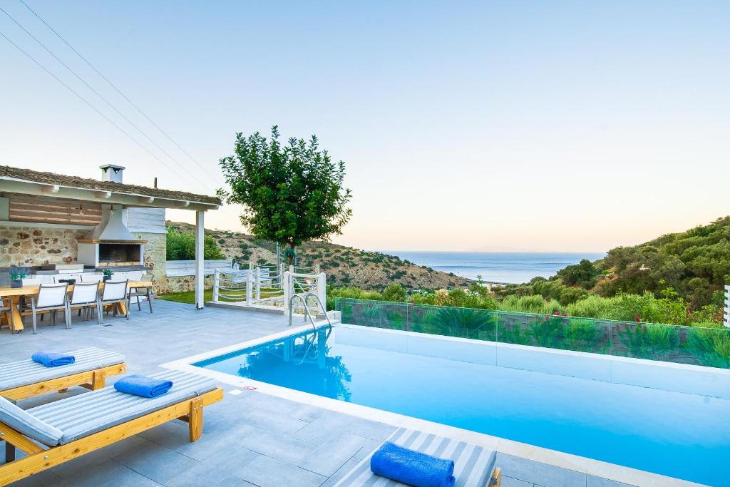 a villa with a swimming pool with a view of the ocean at Castro Villas Crete in Palaiokastro