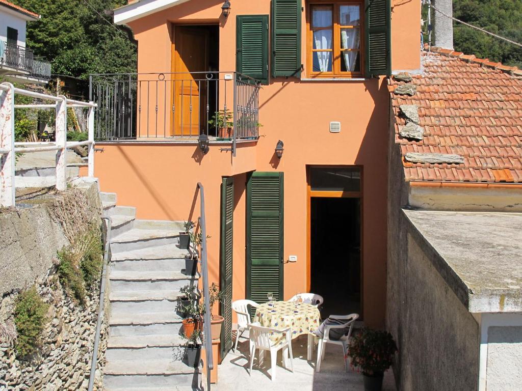 uma casa laranja com uma mesa e cadeiras em Apartment Daniele by Interhome em Onzo