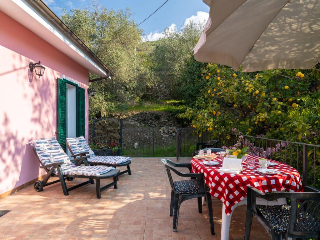 une terrasse avec une table, des chaises et un parasol dans l'établissement Holiday Home Casa Trinità by Interhome, à Diano Borello