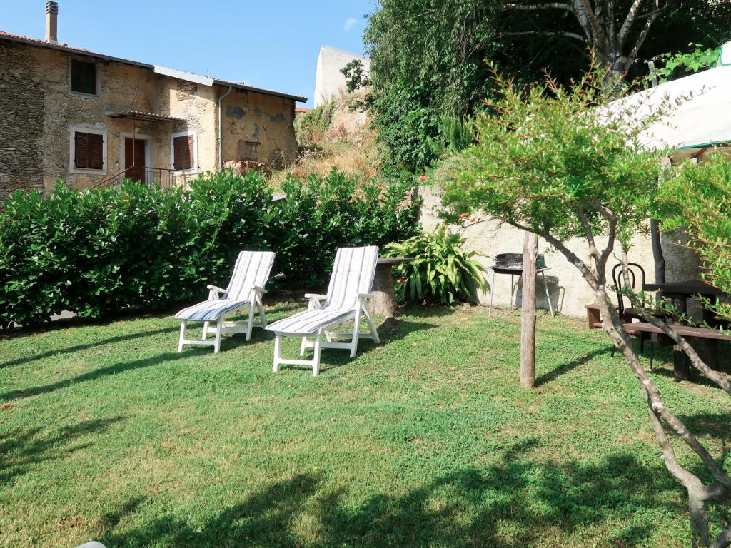 zwei weiße Stühle auf dem Rasen im Garten in der Unterkunft Apartment Luca by Interhome in Onzo