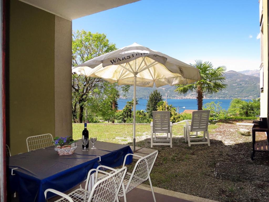einen Tisch mit einer Flasche Wein und einem Sonnenschirm in der Unterkunft Apartment Euroville-6 by Interhome in Germignaga