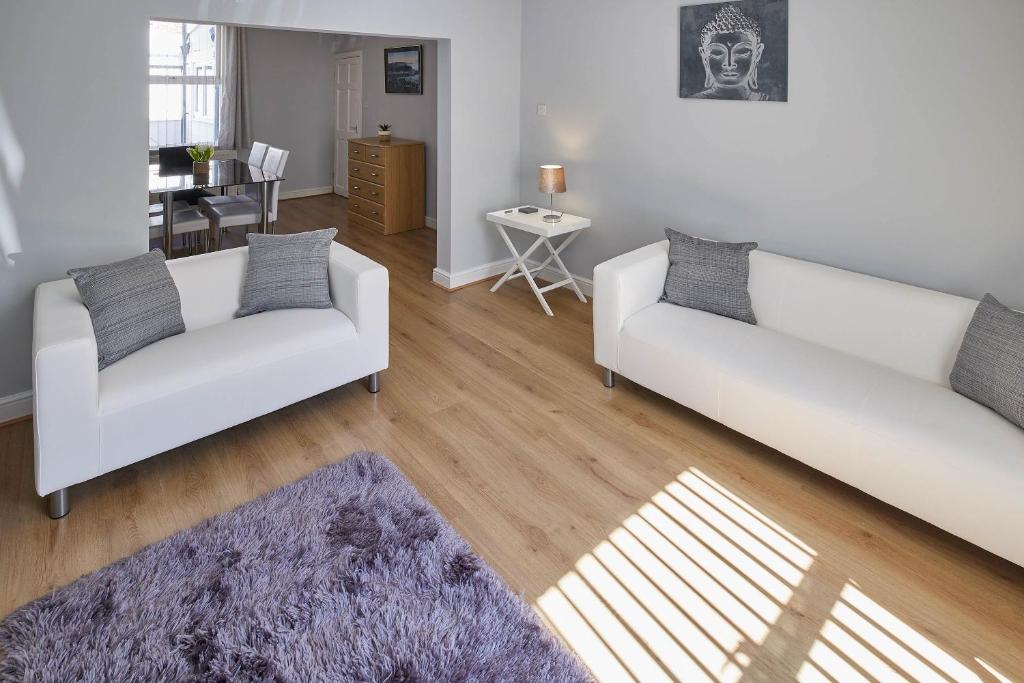 ein Wohnzimmer mit 2 weißen Sofas und einem Tisch in der Unterkunft Host & Stay - 1 Oswy Street in Whitby