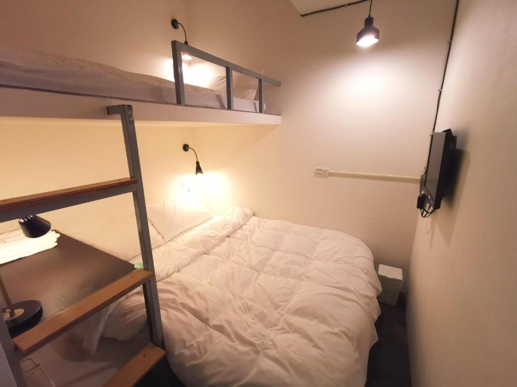 a small room with a bed and two bunk beds at Inn Cube - Taipei Main Station in Taipei