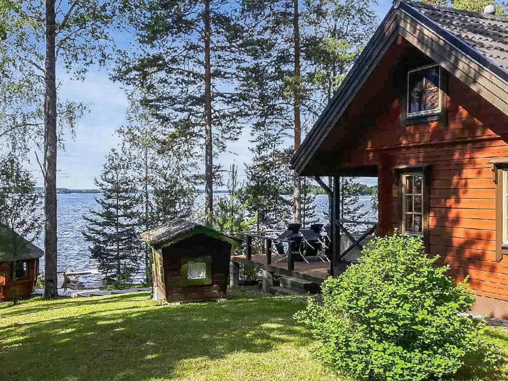 a log cabin with a view of the water at Holiday Home Puolen hehtaarin metsä by Interhome in Haapaniemi