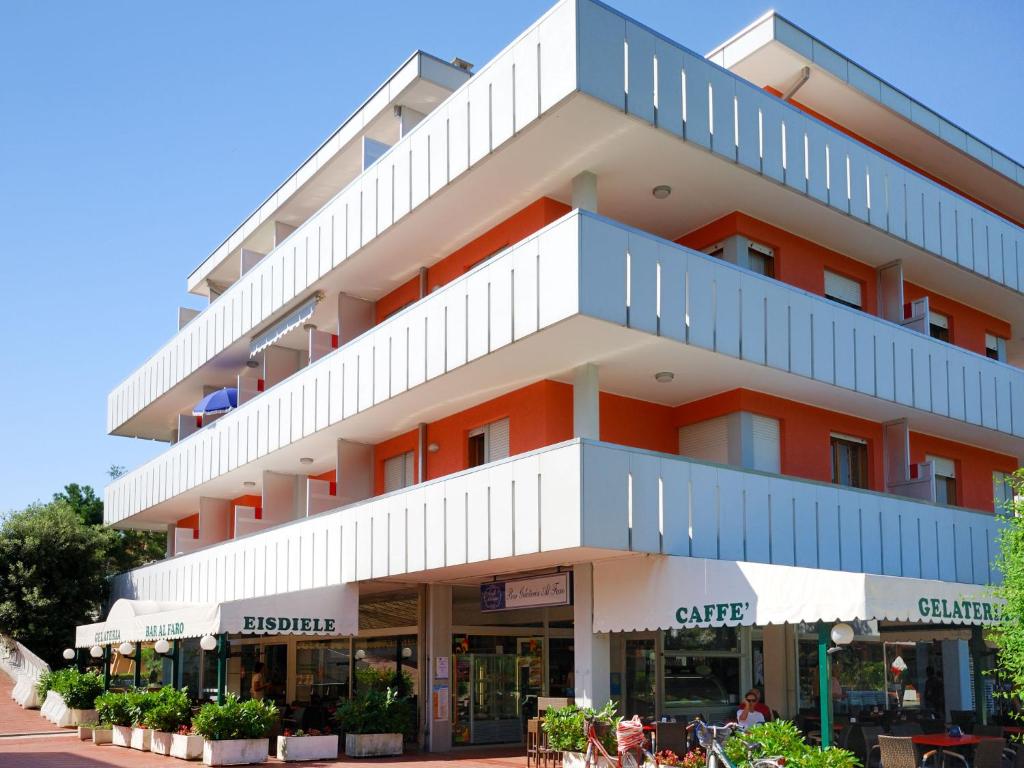 um edifício de apartamentos com uma cor laranja e branca em Apartment Cavallino by Interhome em Bibione