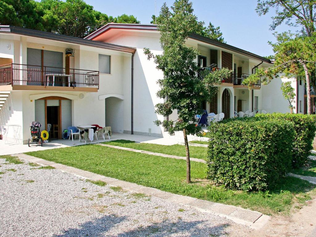 una gran casa blanca con un seto delante de ella en Apartment Villaggio Delfino-2 by Interhome, en Bibione