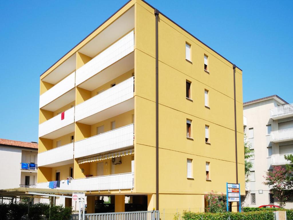 ein gelbes und weißes Apartmenthaus in der Unterkunft Apartment Pleione-1 by Interhome in Bibione