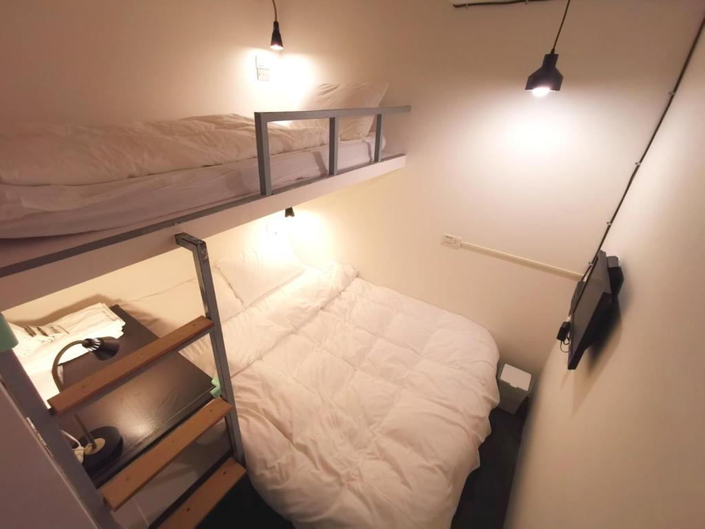 a small room with two bunk beds and lights at Inn Cube - Taipei Main Station in Taipei