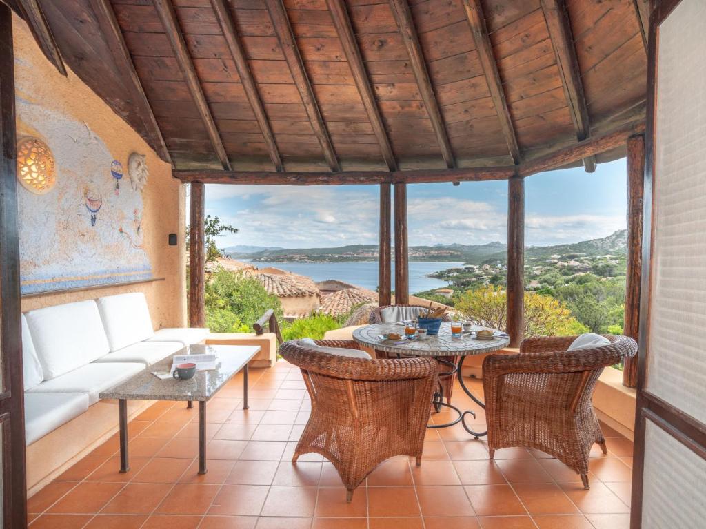 un soggiorno con tavolo, sedie e vista di Holiday Home Casa del Sole by Interhome a Porto Rafael